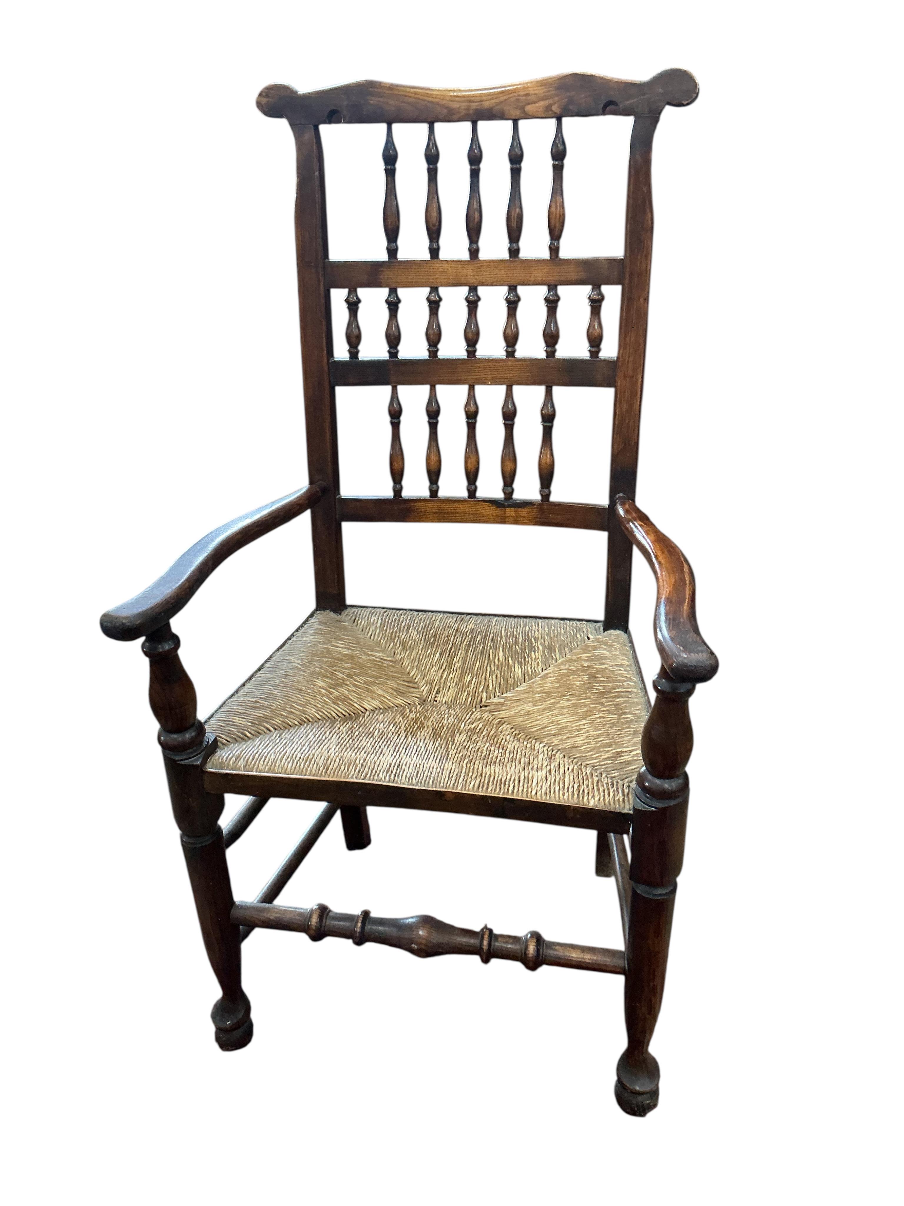 A harlequin set of eight (six plus two) Derbyshire style elm and beech rush seat spindle back dining chairs, two with arms